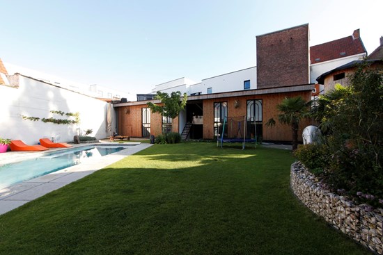 Een gast geniet van het terras en de tuin van Koto B&B in Antwerpen